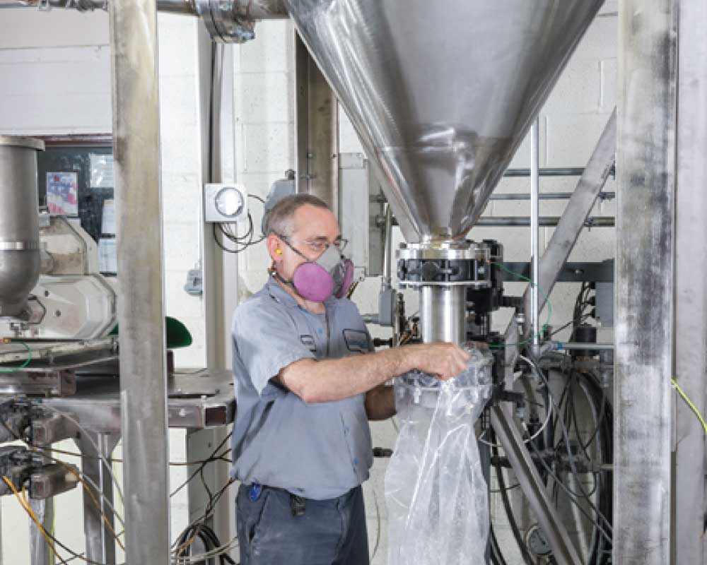 Person collecting media from a pulverizing roller mill