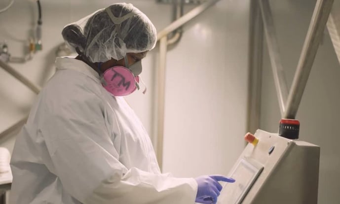 CPS employee in PPE using toll processing equipment