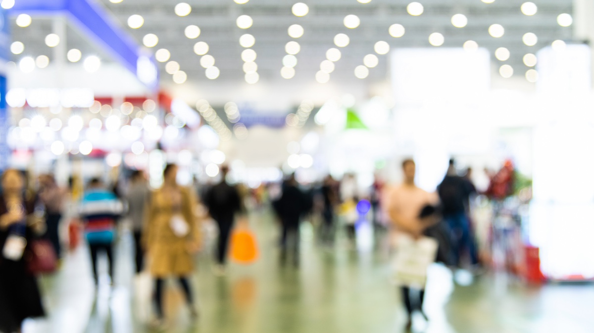 Crowds walking on exhibition floor.